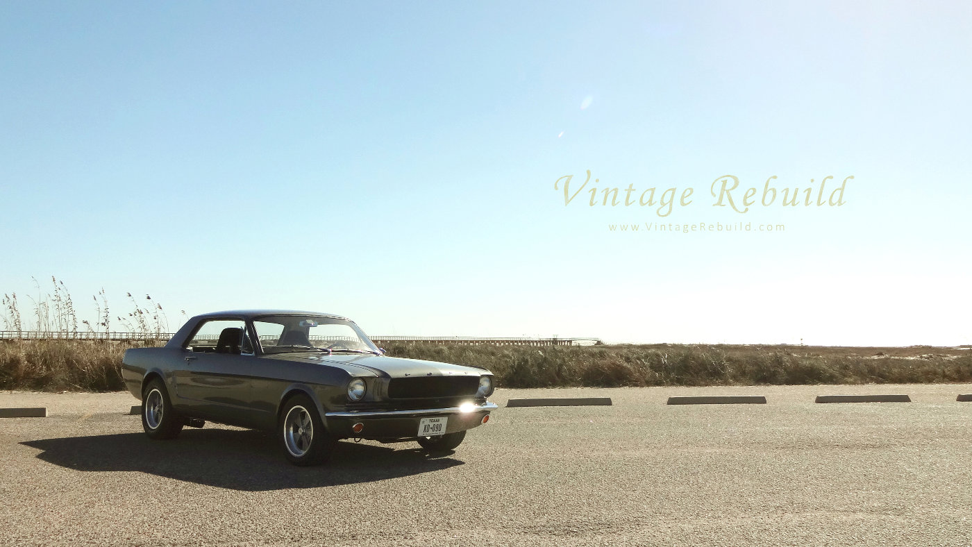 1965 Mustang 289 V8 Ford Coupe Picture aggressive stance near pier. Muscle car 1965 Ford Mustang. A gray 1965 Mustang with a Ford 289 V8. Classic American car, the 1965 Ford Mustang, here in dragster stance.