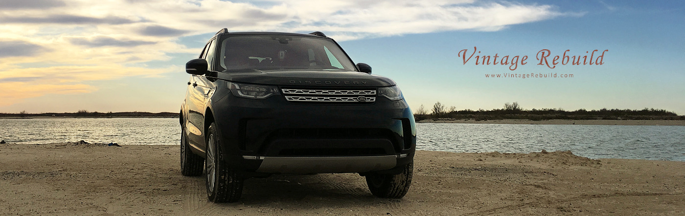 Black 2017 Land Rover Discovery HSE on beach at sunset.