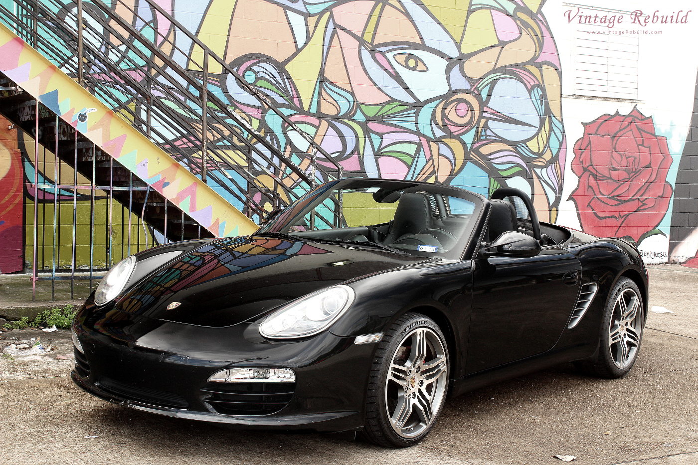 Black Porsche Boxster S 987.2 at Graffiti Wall Houston with Rose. Picture of German luxury car, the Porsche Boxster S 987.2. Convertible top down, a black Porsche Boxster S 987.