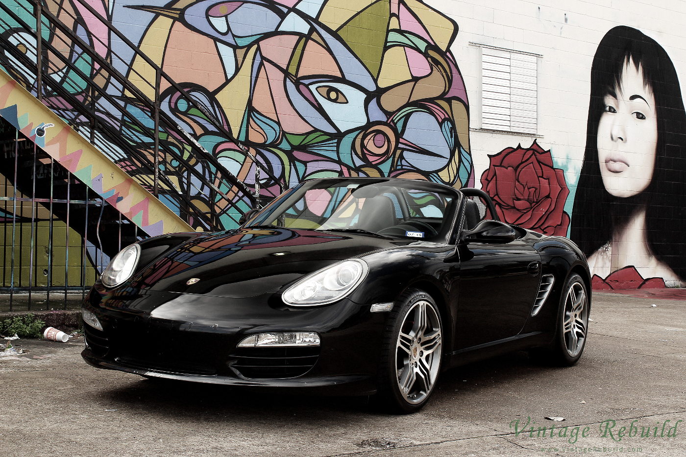 Black Porsche Boxster S 987.2 at Graffiti Wall Houston with Selena. Pictures of German luxury car, a black Porsche Boxster S 987.2. Convertible car the Porsche Boxster.