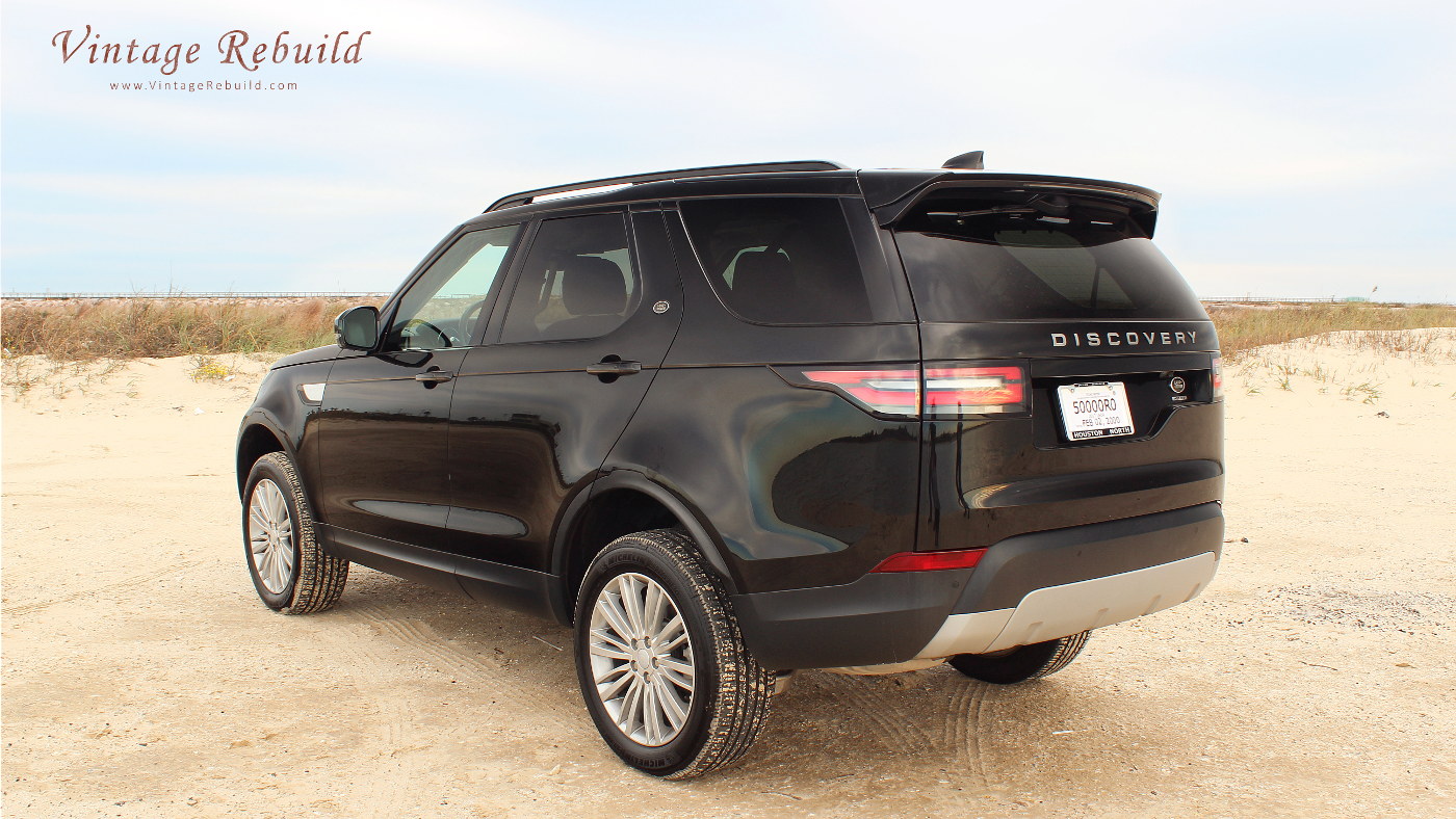 Black 2017 Land Rover Discovery HSE Luxury SUV offroad driving on beach sand at sunset, Jetty Park, Matagorda, Texas.